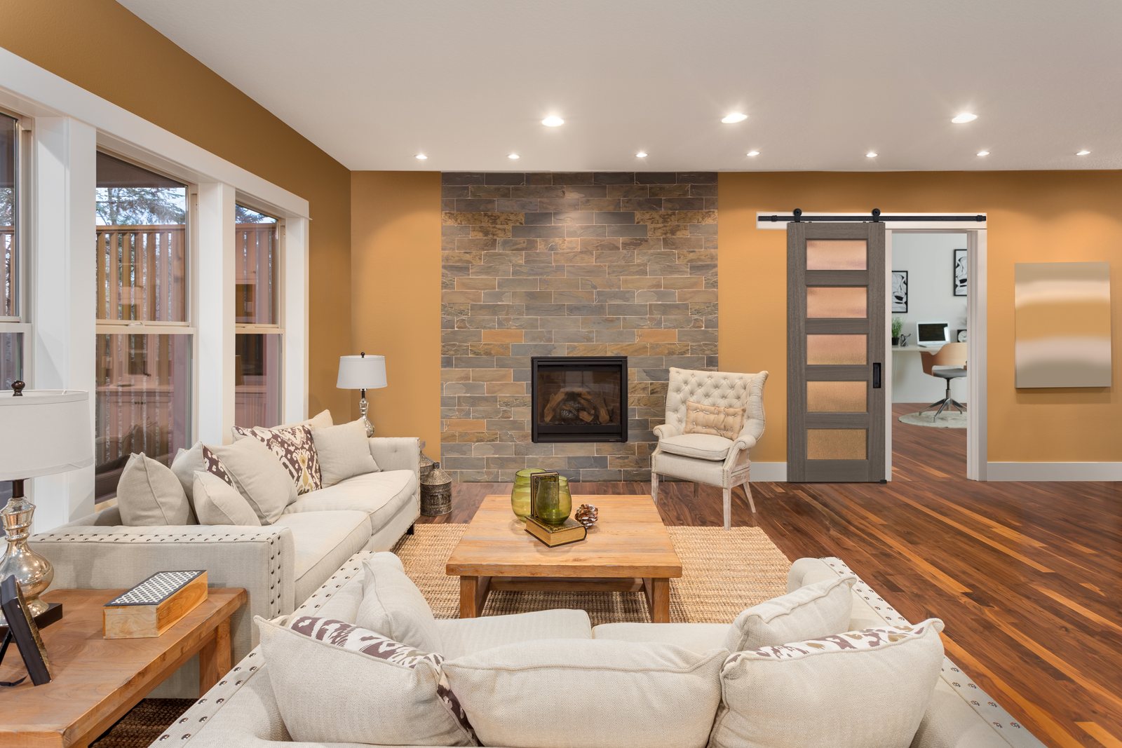 A 5 Lite Continental barn door with rain glass, open on a stainless steel rail beside a living room fireplace